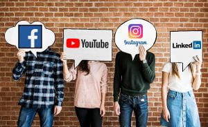 4 people standing in line holding sighs with social media logos