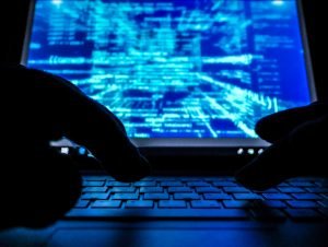A hacker working on the keyboard of a laptop